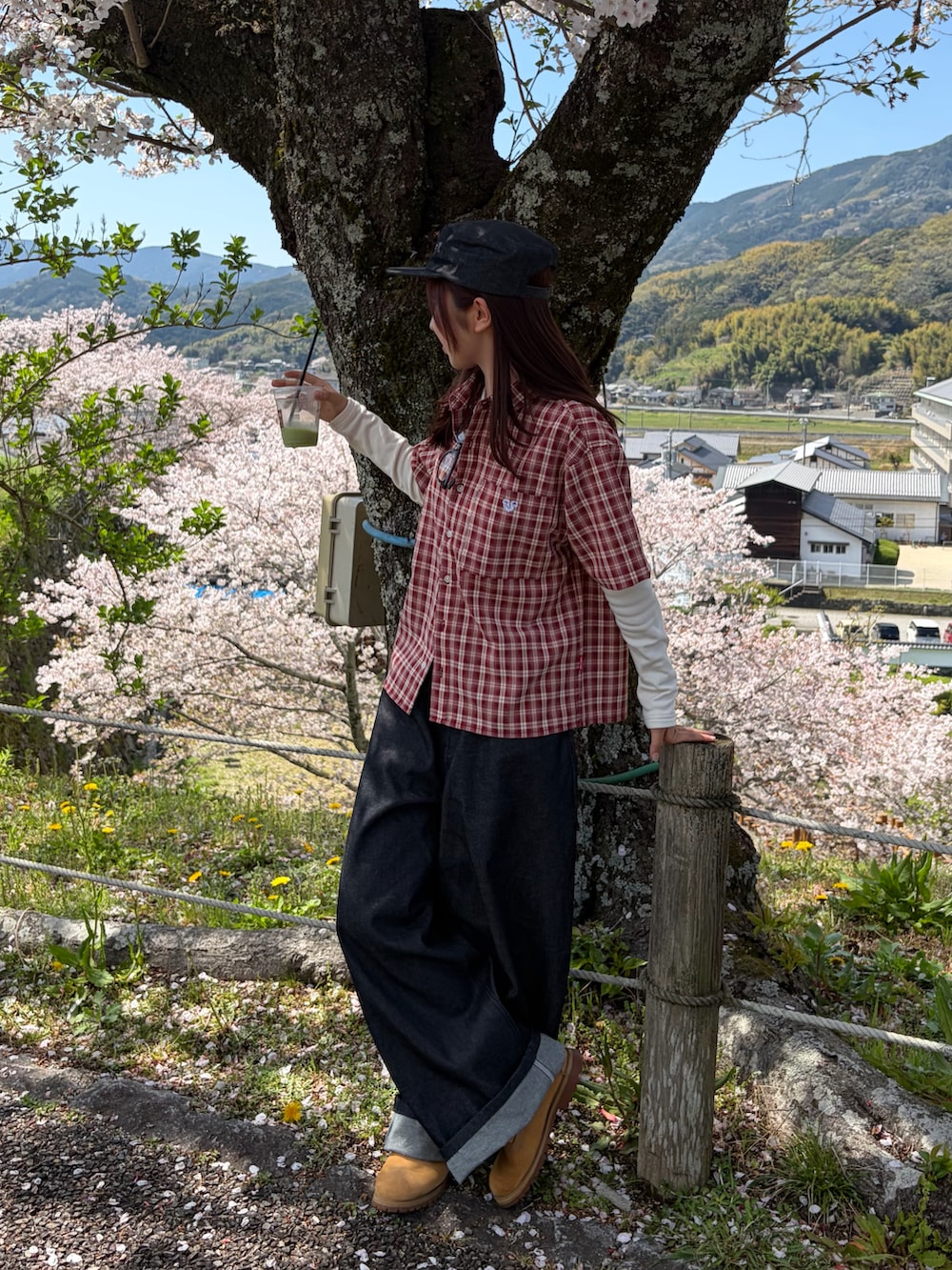 レッド系のシャツ/ブラウス、ブラック系のデニムパンツ、イエロー系のブーツを着用したレディースの春コーディネートの3枚目の写真