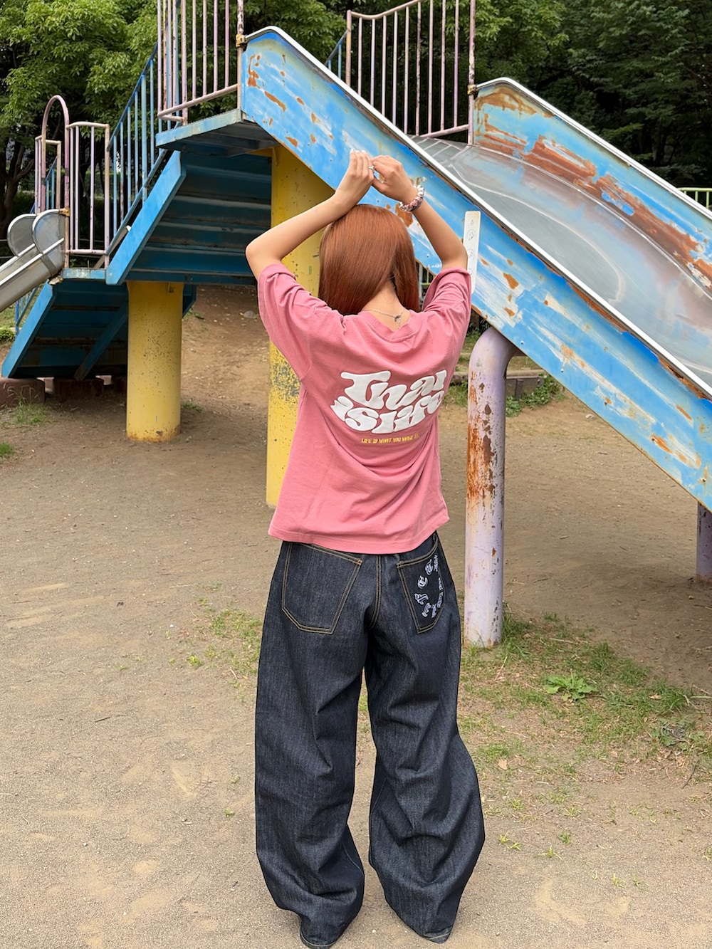 ピンク系のTシャツ/カットソー、ブラック系のデニムパンツ、ピンク系のスニーカーを着用したレディースの夏コーディネートの2枚目の写真