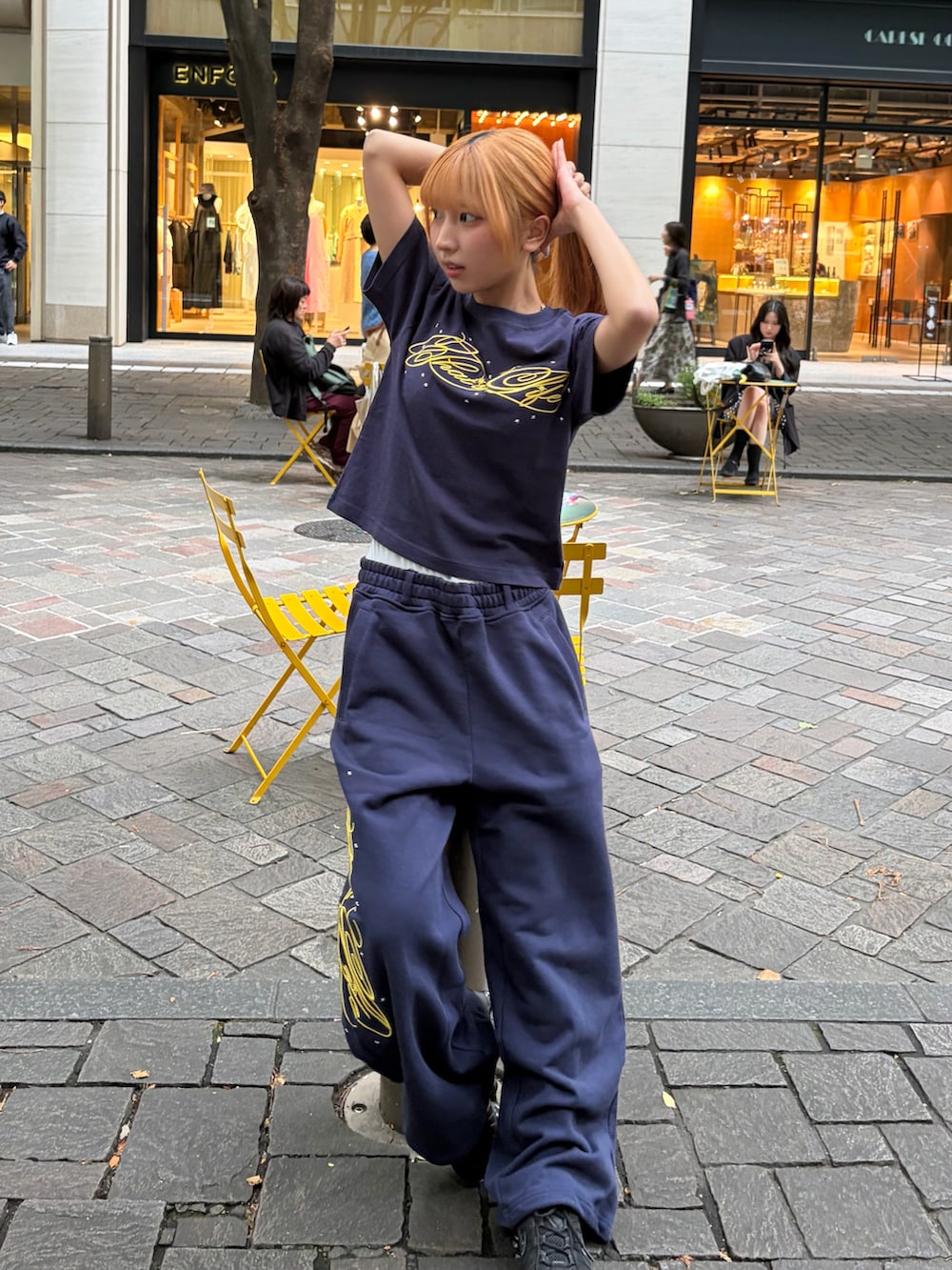 ブルー系のTシャツ/カットソー、ブルー系のスウェットパンツ、ブラック系のスニーカーを着用したレディースの春コーディネートの2枚目の写真
