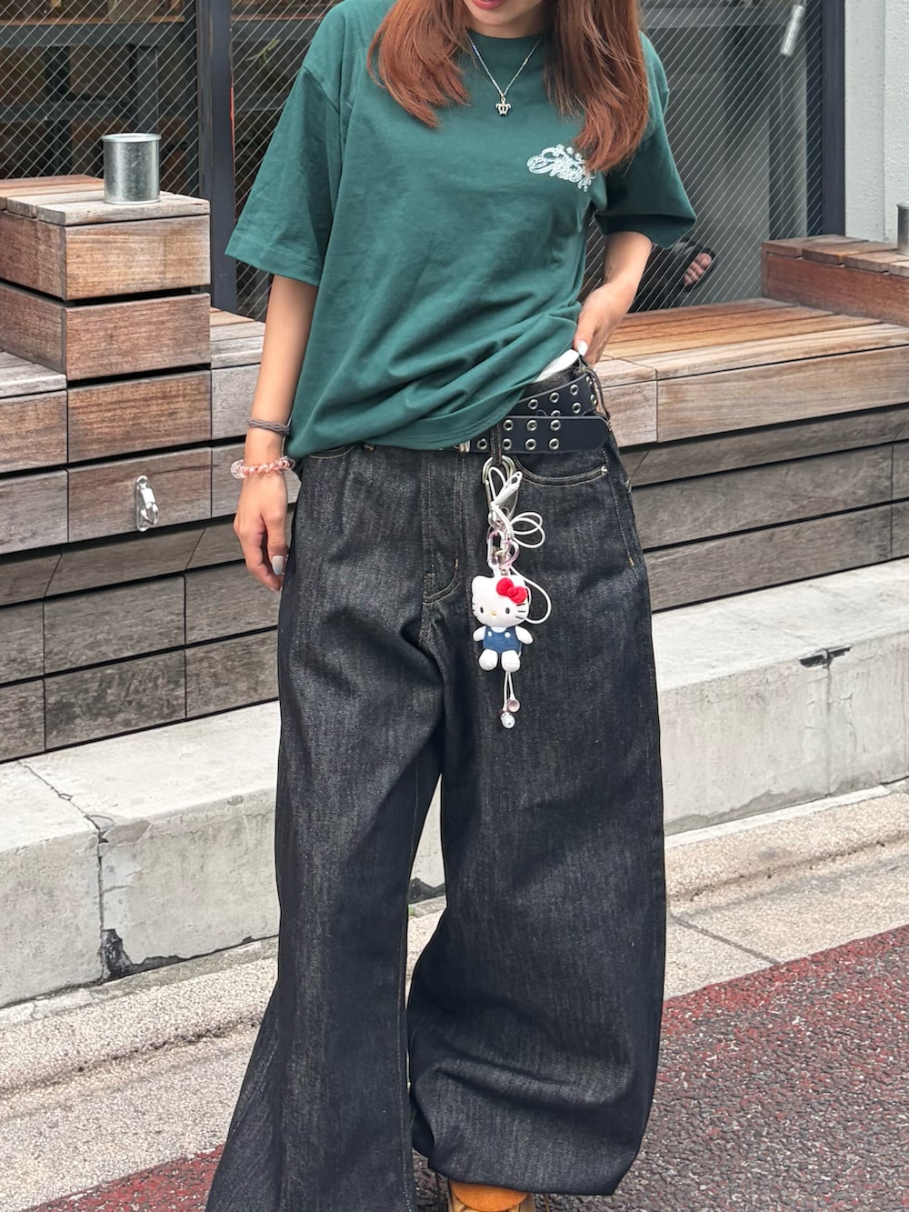 グリーン系のTシャツ/カットソー、ブラック系のデニムパンツ、イエロー系のブーツを着用したレディースの夏コーディネートの3枚目の写真
