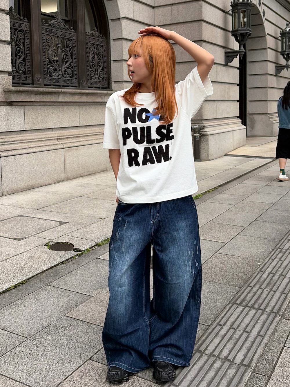 ホワイト系のTシャツ/カットソー、ブルー系のデニムパンツ、ブラック系のスニーカーを着用したレディースの春コーディネートの2枚目の写真