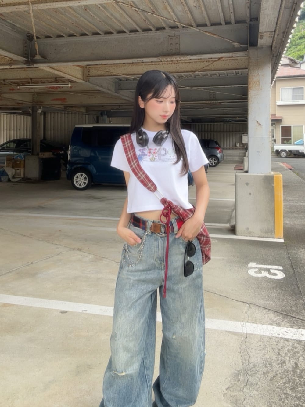 ホワイト系のTシャツ/カットソー、レッド系のショルダーバッグ、ブルー系のデニムパンツを着用したレディースの春コーディネートの3枚目の写真