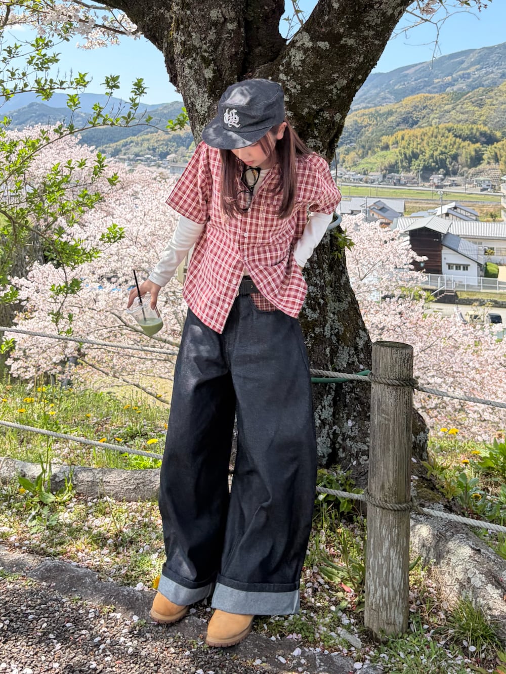 レッド系のシャツ/ブラウス、ブラック系のデニムパンツ、イエロー系のブーツを着用したレディースの春コーディネートの2枚目の写真