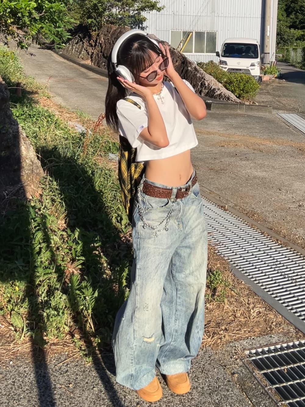 ホワイト系のTシャツ/カットソー、ブルー系のデニムパンツ、ブラウン系のスニーカーを着用したレディースの春コーディネートの3枚目の写真