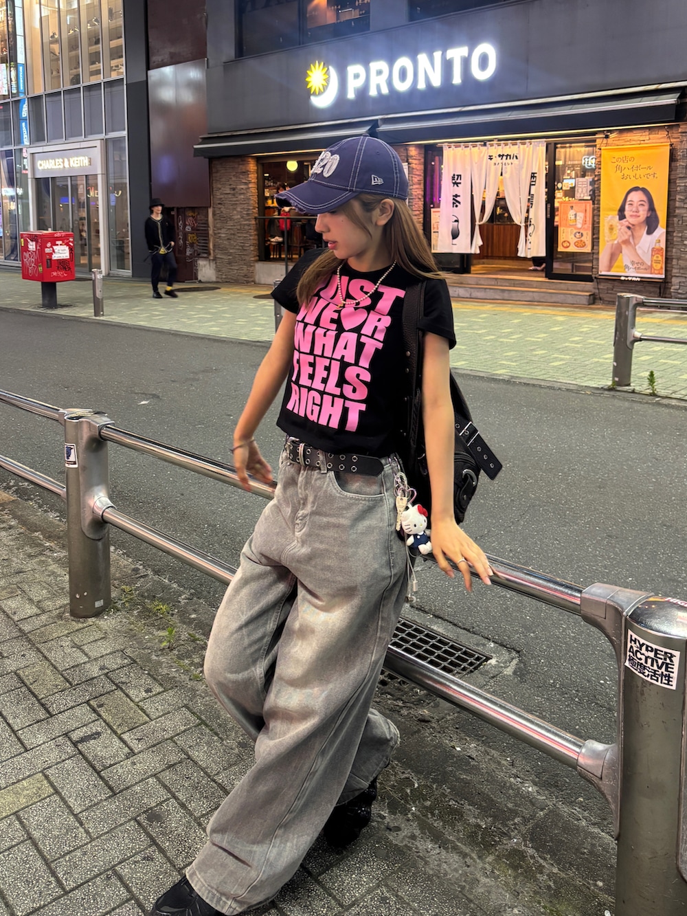 ブラック系のTシャツ/カットソー、ブラック系のショルダーバッグ、グレー系のデニムパンツを着用したレディースの夏コーディネートの2枚目の写真