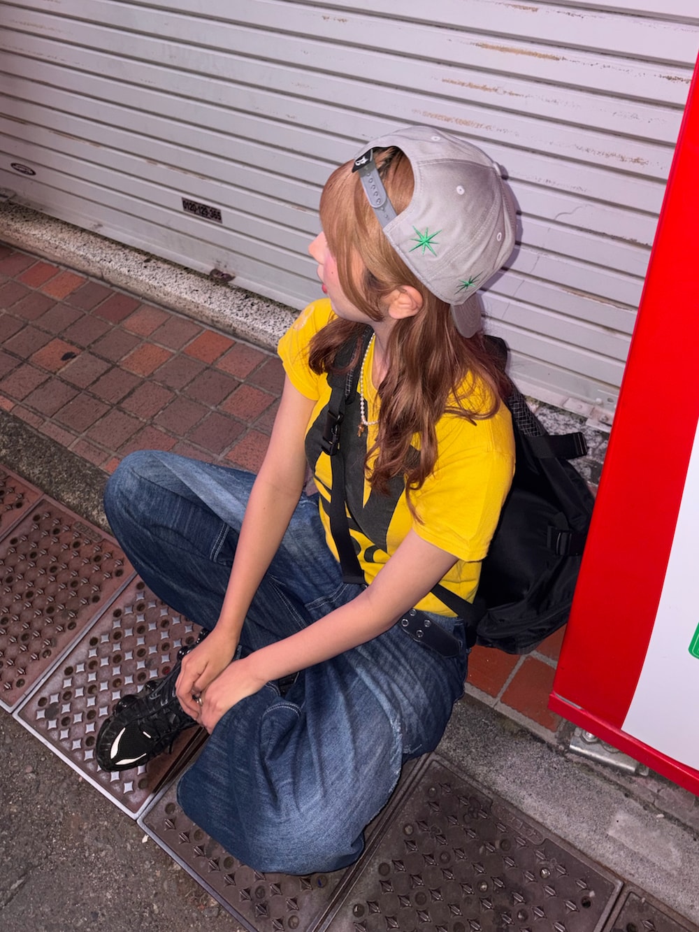 イエロー系のトップス、ブルー系のデニムパンツ、ブラック系のスニーカーを着用したレディースの夏コーディネートの4枚目の写真