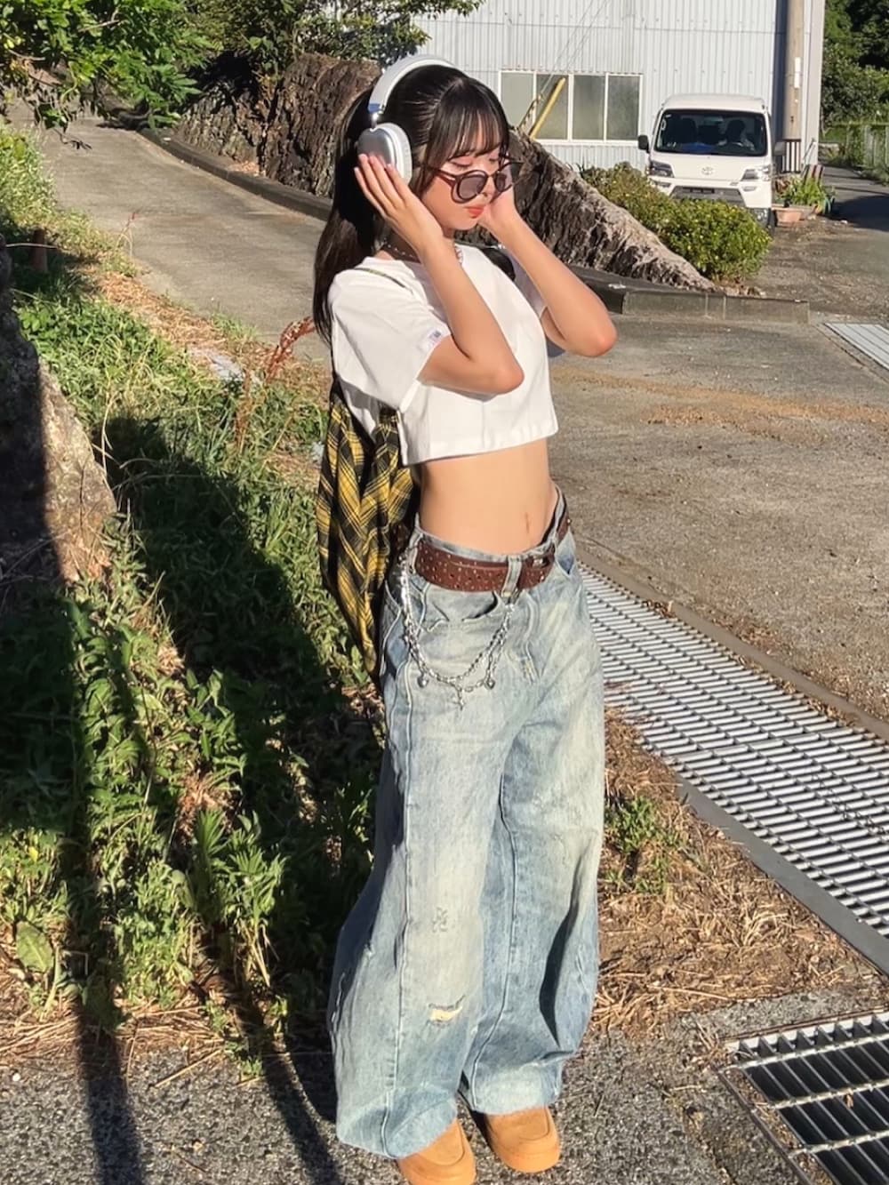 ホワイト系のTシャツ/カットソー、ブルー系のデニムパンツ、ブラウン系のスニーカーを着用したレディースの春コーディネートの2枚目の写真