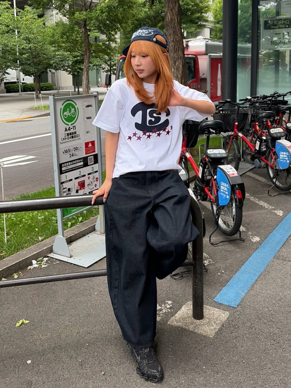 ブラック系のスニーカー、ホワイト系のTシャツ/カットソー、ブラック系のデニムパンツを着用したレディースの春コーディネートの2枚目の写真