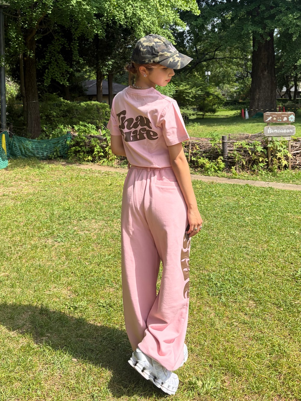 ピンク系のスウェットパンツ、ピンク系のTシャツ/カットソー、ホワイト系のスニーカーを着用したレディースの夏コーディネートの2枚目の写真
