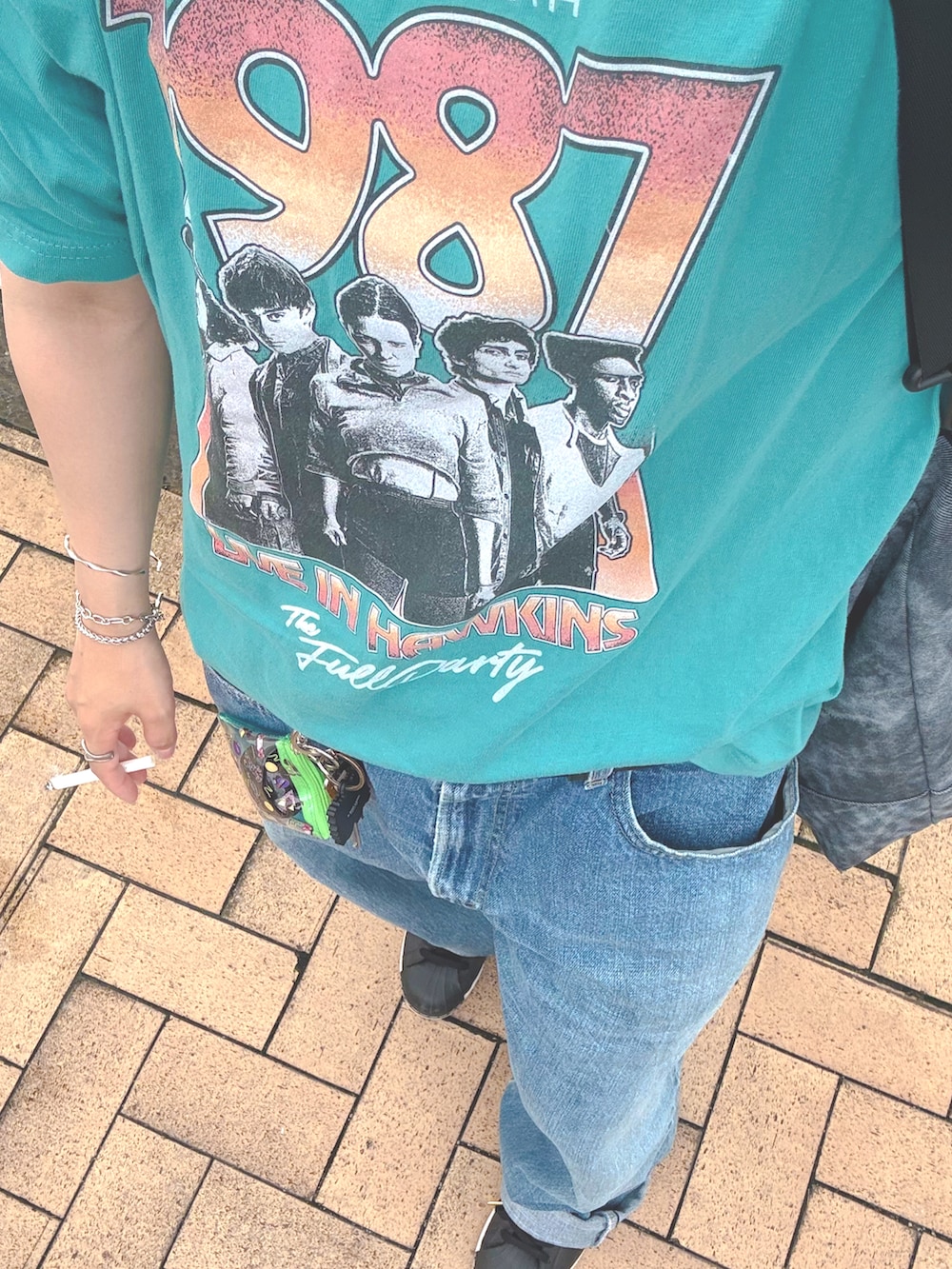ブルー系のTシャツ/カットソー、ブルー系のデニムパンツ、ブラック系のスニーカーを着用したレディースの秋コーディネートの2枚目の写真
