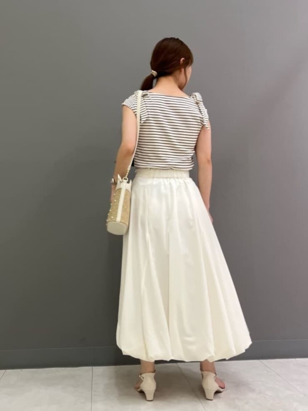 ホワイト系のショルダーバッグ、ホワイト系のサンダル、ホワイト系のTシャツ/カットソーを着用したレディースの夏コーディネートの2枚目の写真
