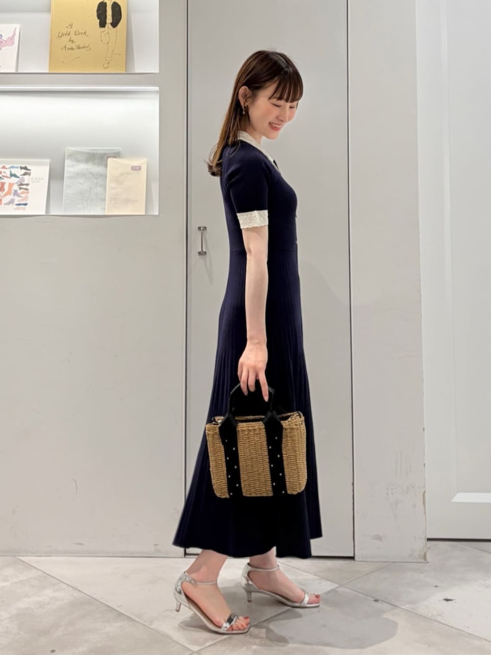 ブラック系のかごバッグ、ブルー系のワンピースを着用したレディースの夏コーディネートの3枚目の写真