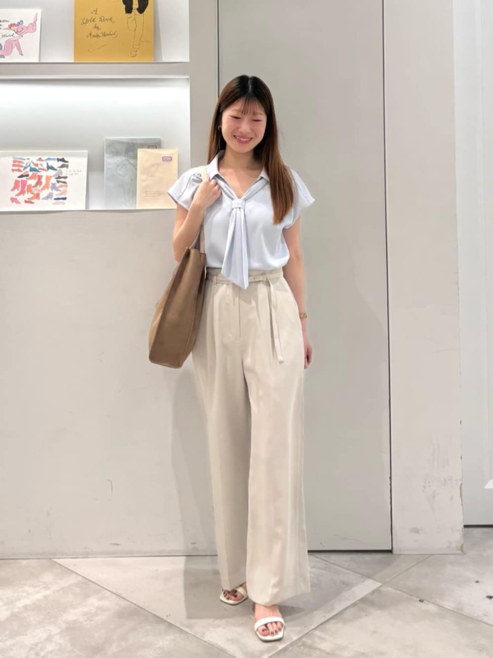 ベージュ系のその他パンツ、ブルー系のシャツ/ブラウス、ベージュ系のトートバッグを着用したレディースの夏コーディネートの2枚目の写真