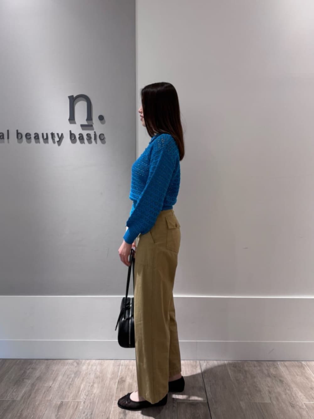 ブラック系のバレエシューズ、ブルー系のポロシャツ、ベージュ系のその他パンツを着用したレディースの春コーディネートの3枚目の写真