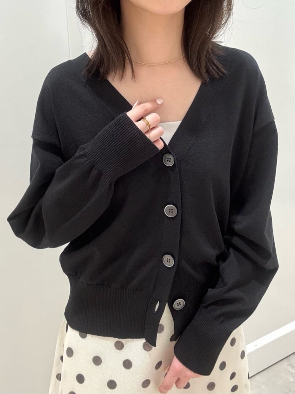 ブラック系のカーディガン/ボレロ、ホワイト系のスカートを着用したレディースの春コーディネートの3枚目の写真