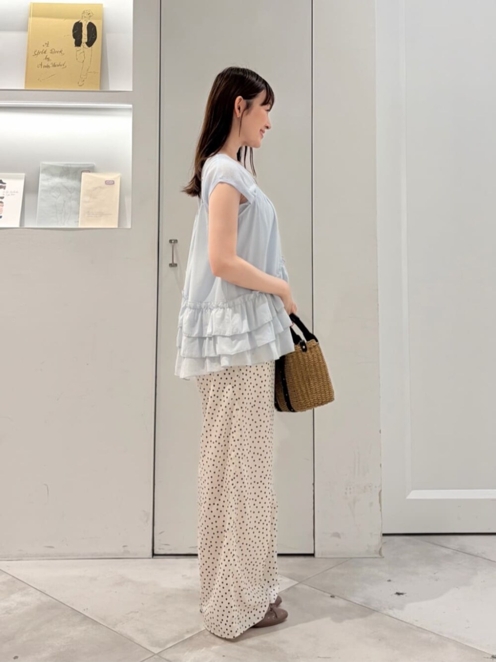 ブルー系のニット/セーター、ホワイト系のその他パンツ、ブラック系のかごバッグを着用したレディースの夏コーディネートの2枚目の写真