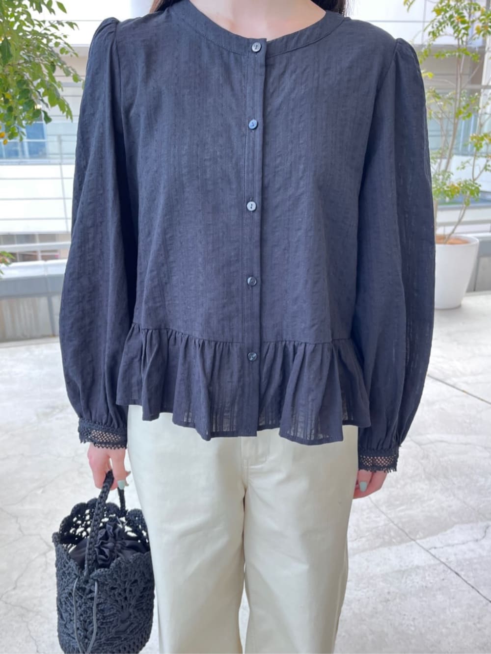 ブラック系のサンダル、ブラック系のハンドバッグ、ベージュ系のチノパンツを着用したレディースの春コーディネートの4枚目の写真