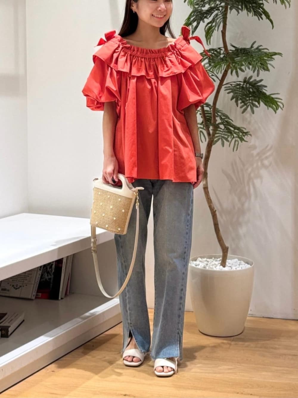 ブルー系のデニムパンツ、オレンジ系のシャツ/ブラウスを着用したレディースの春コーディネートの3枚目の写真