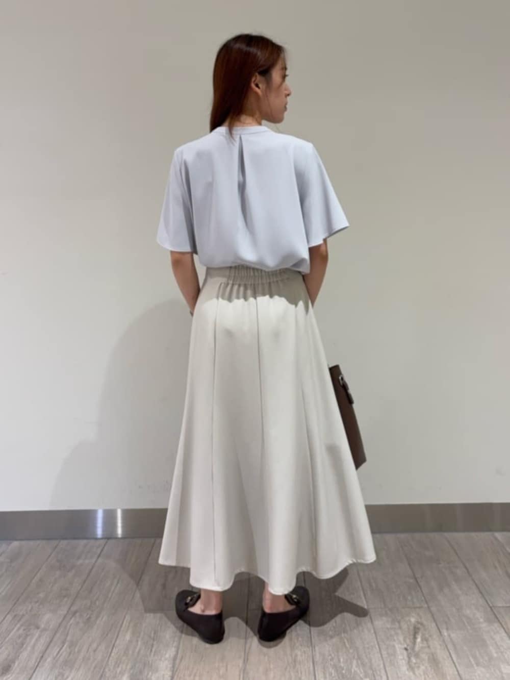 ブルー系のシャツ/ブラウス、ベージュ系のスカート、ブラック系のローファーを着用したレディースの春コーディネートの3枚目の写真