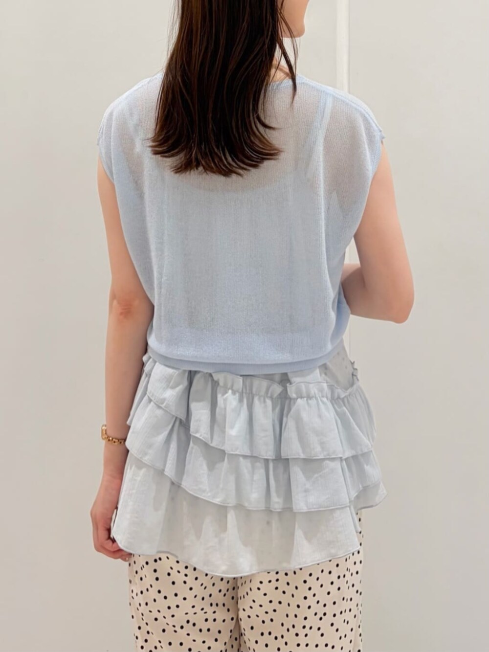 ブルー系のニット/セーター、ホワイト系のその他パンツ、ブラック系のかごバッグを着用したレディースの夏コーディネートの5枚目の写真