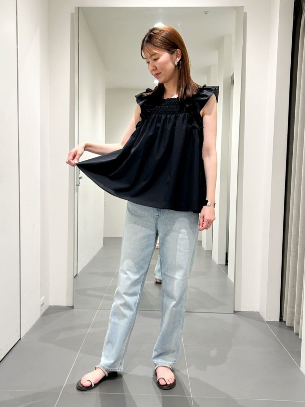 ブラック系のシャツ/ブラウス、ブルー系のデニムパンツを着用したレディースの夏コーディネートの3枚目の写真