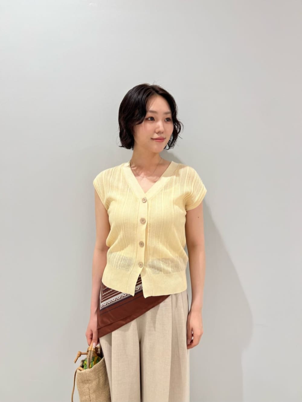 イエロー系のカーディガン/ボレロ、ベージュ系のその他パンツ、ベージュ系のショルダーバッグを着用したレディースの夏コーディネートの5枚目の写真