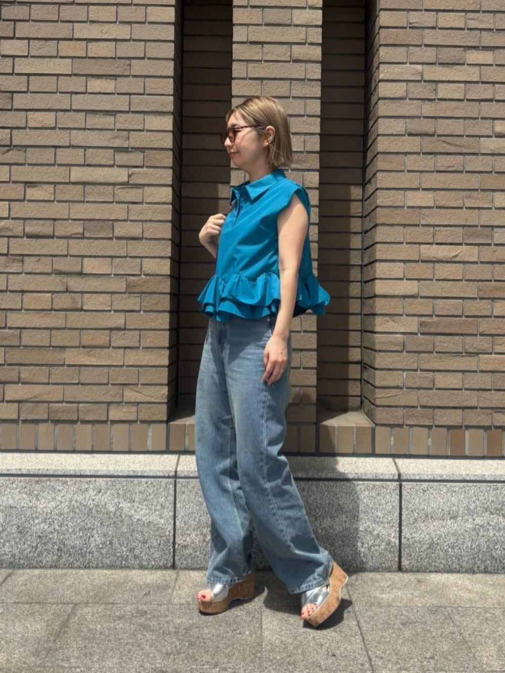 ブルー系のデニムパンツ、ブルー系のシャツ/ブラウス、オレンジ系のボストンバッグを着用したレディースの春コーディネートの2枚目の写真
