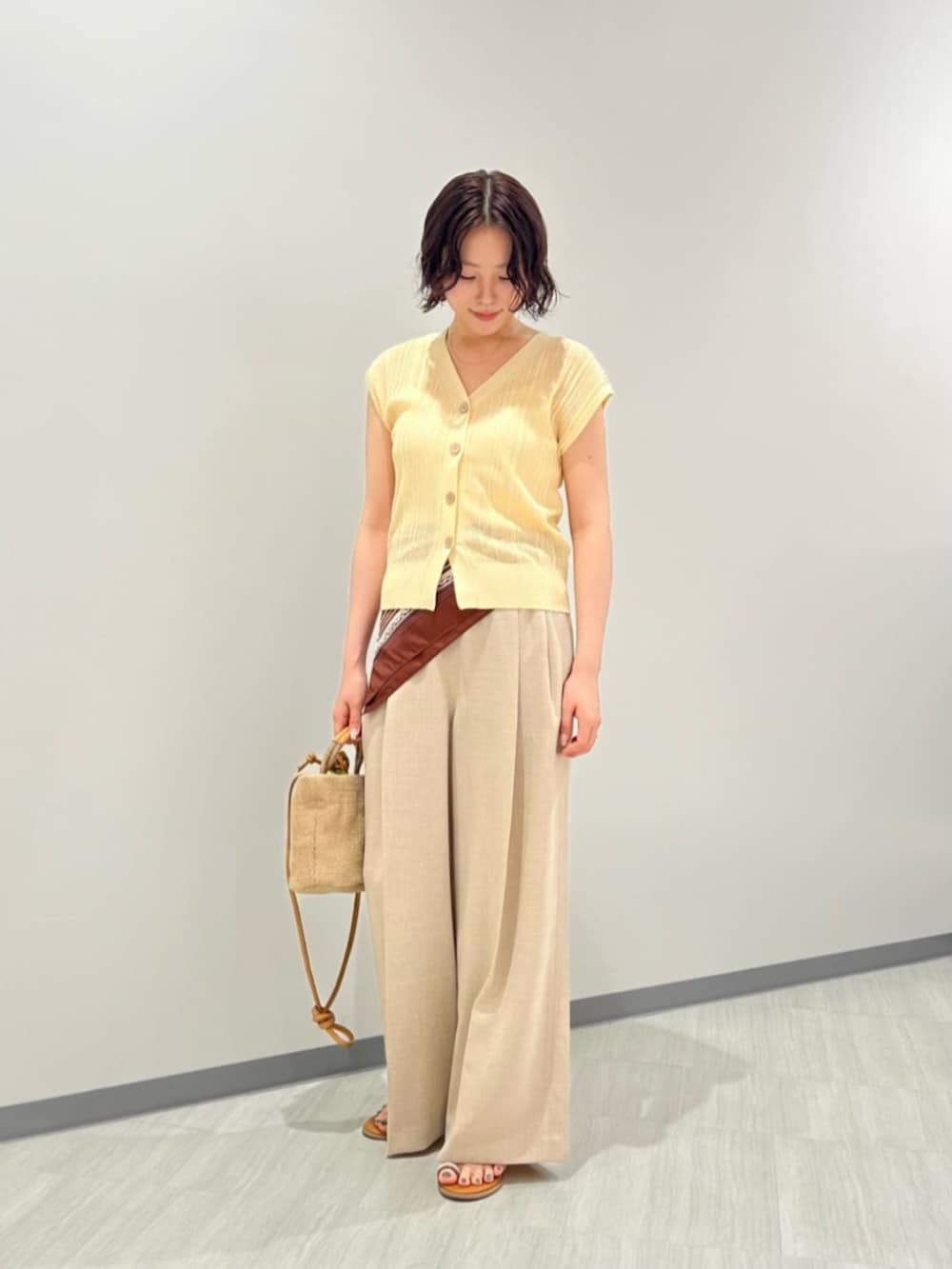 イエロー系のカーディガン/ボレロ、ベージュ系のその他パンツ、ベージュ系のショルダーバッグを着用したレディースの夏コーディネートの2枚目の写真