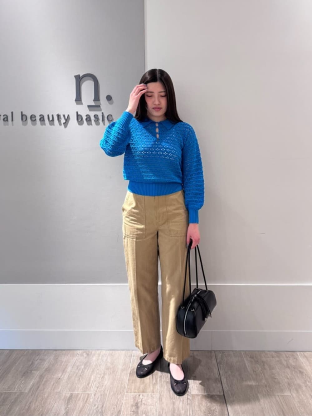 ブラック系のバレエシューズ、ブルー系のポロシャツ、ベージュ系のその他パンツを着用したレディースの春コーディネートの2枚目の写真