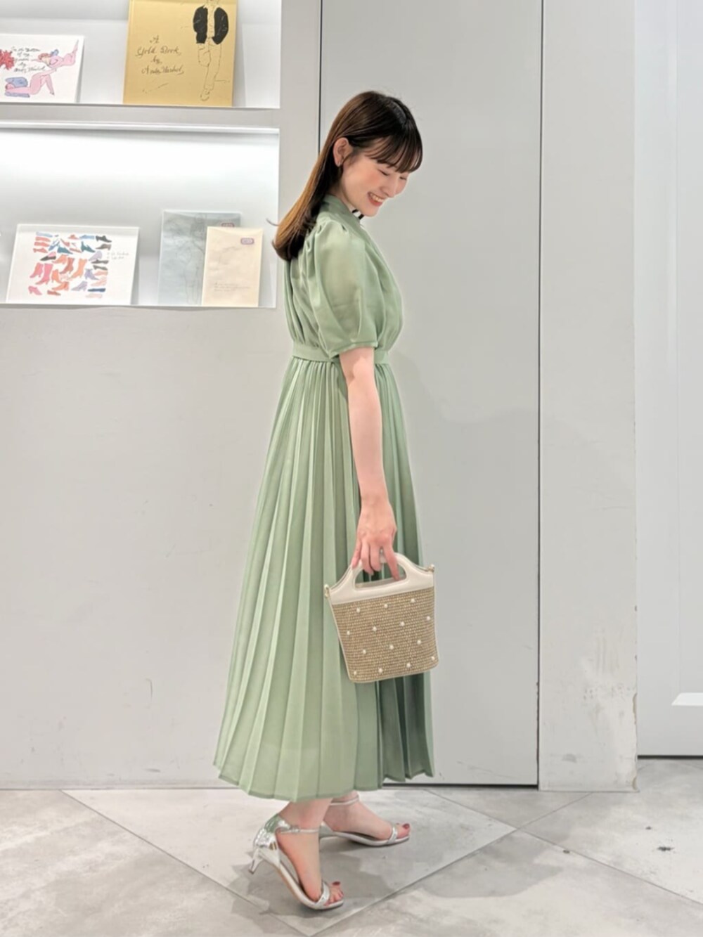 ホワイト系のショルダーバッグ、グリーン系のワンピースを着用したレディースの夏コーディネートの3枚目の写真