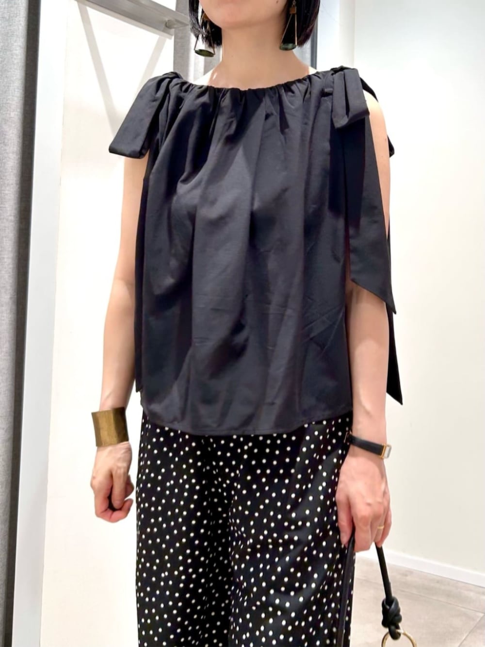 ホワイト系のショルダーバッグ、ブラック系のシャツ/ブラウス、ブラック系のその他パンツを着用したレディースの夏コーディネートの8枚目の写真