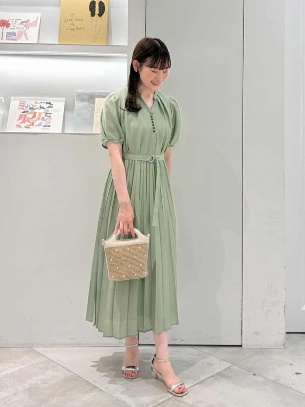 ホワイト系のショルダーバッグ、グリーン系のワンピースを着用したレディースの夏コーディネートの2枚目の写真