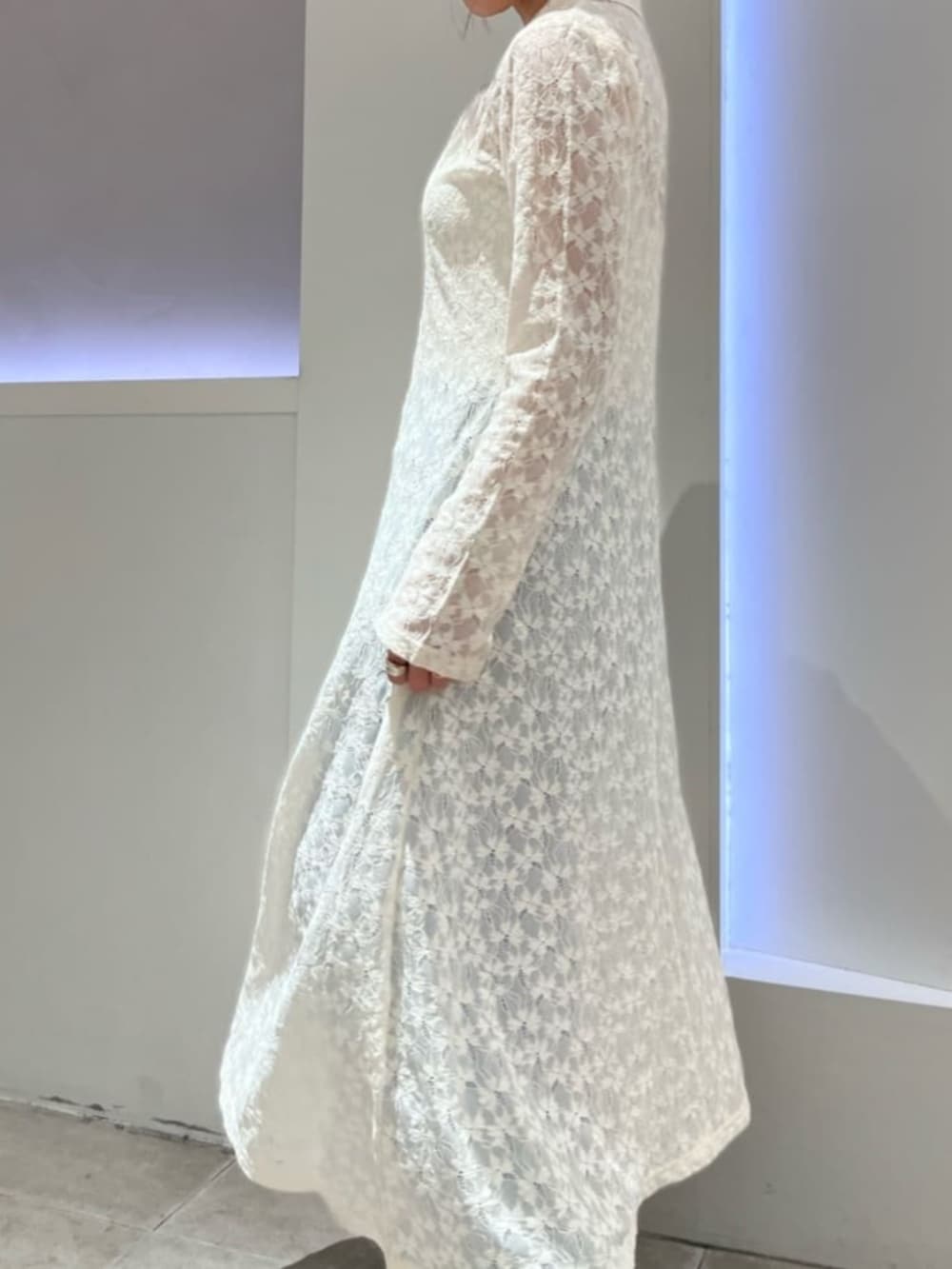 ホワイト系のシャツワンピース、ホワイト系のキャミソール、ブルー系のデニムパンツを着用したレディースの春コーディネートの4枚目の写真