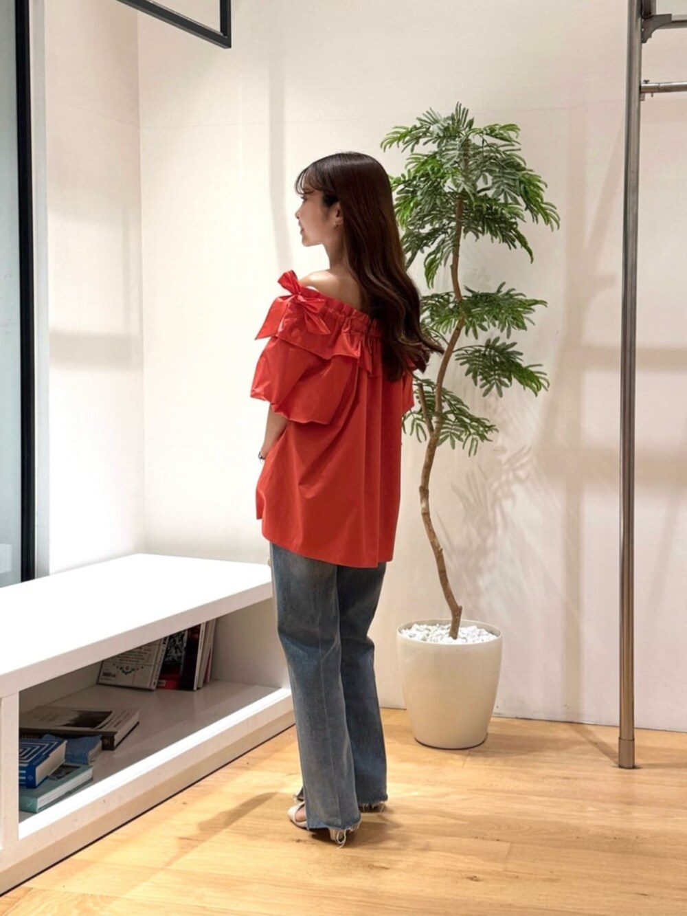 ブルー系のデニムパンツ、オレンジ系のシャツ/ブラウスを着用したレディースの春コーディネートの2枚目の写真