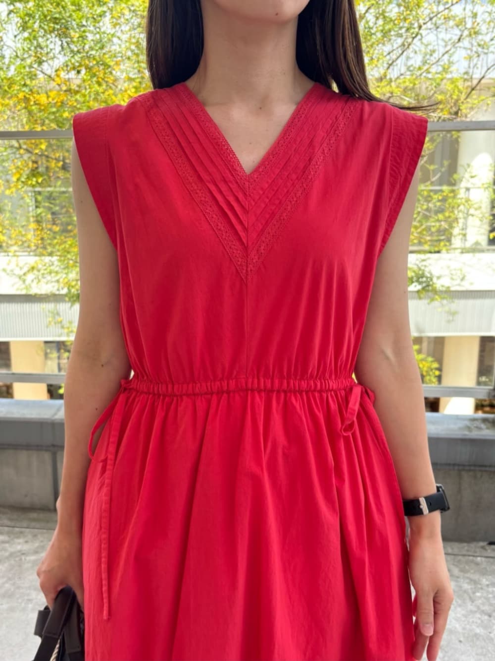 ブルー系のデニムパンツ、レッド系のワンピースを着用したレディースの春コーディネートの4枚目の写真