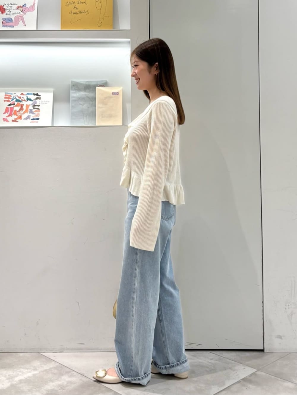 ホワイト系のカーディガン/ボレロ、ブルー系のデニムパンツ、ベージュ系のボストンバッグを着用したレディースの春コーディネートの3枚目の写真