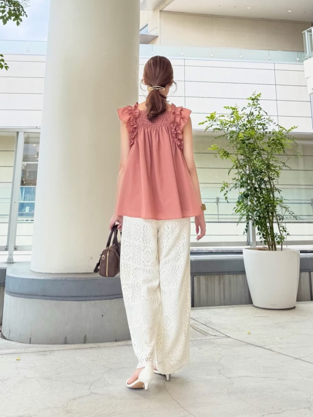 ブラウン系のボストンバッグ、ホワイト系のその他パンツ、オレンジ系のシャツ/ブラウスを着用したレディースの夏コーディネートの5枚目の写真