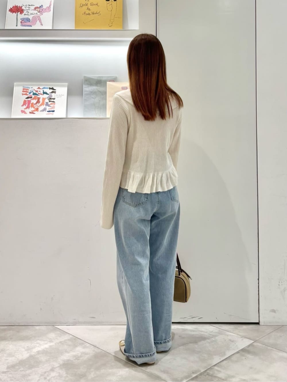 ホワイト系のカーディガン/ボレロ、ブルー系のデニムパンツ、ベージュ系のボストンバッグを着用したレディースの春コーディネートの4枚目の写真