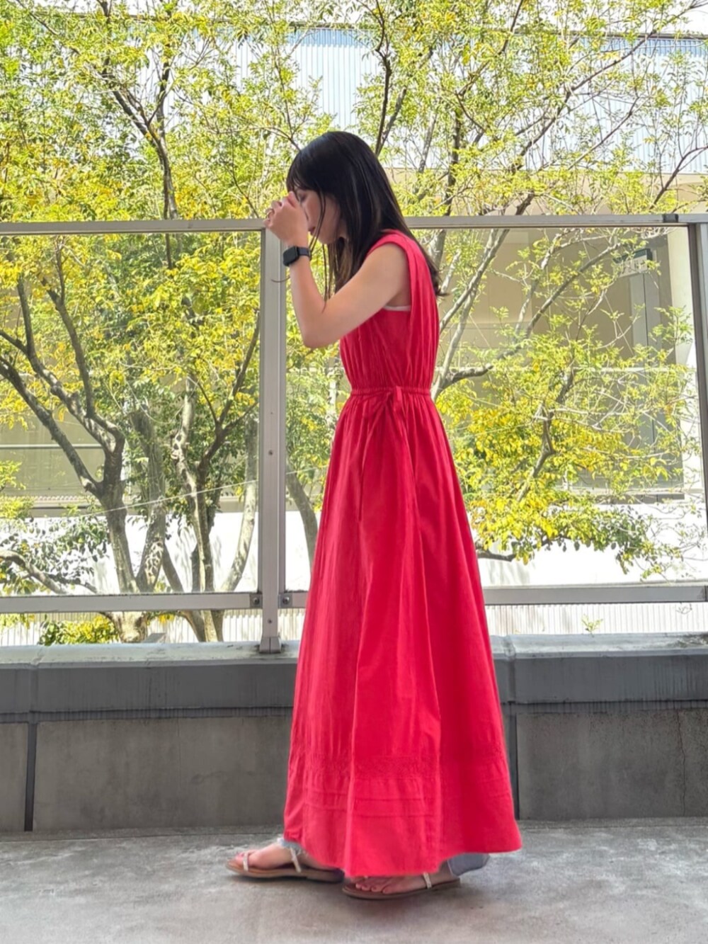 ブルー系のデニムパンツ、レッド系のワンピースを着用したレディースの春コーディネートの2枚目の写真