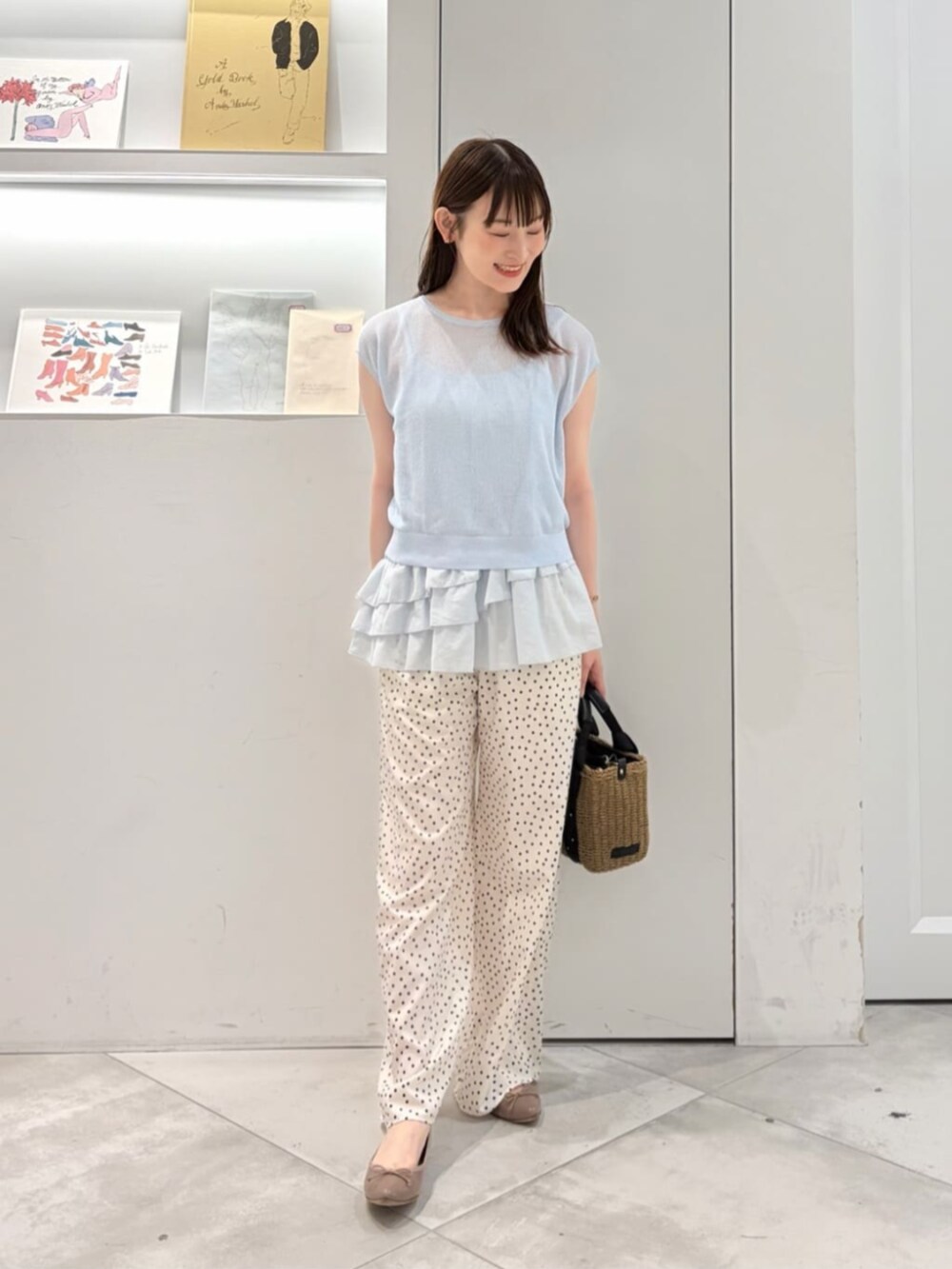 ブルー系のニット/セーター、ホワイト系のその他パンツ、ブラック系のかごバッグを着用したレディースの夏コーディネートの4枚目の写真
