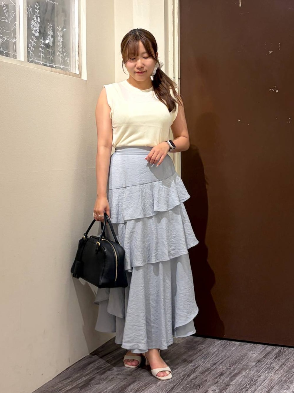 ホワイト系のニット/セーター、グレー系のスカート、ブラック系のハンドバッグを着用したレディースの夏コーディネートの5枚目の写真