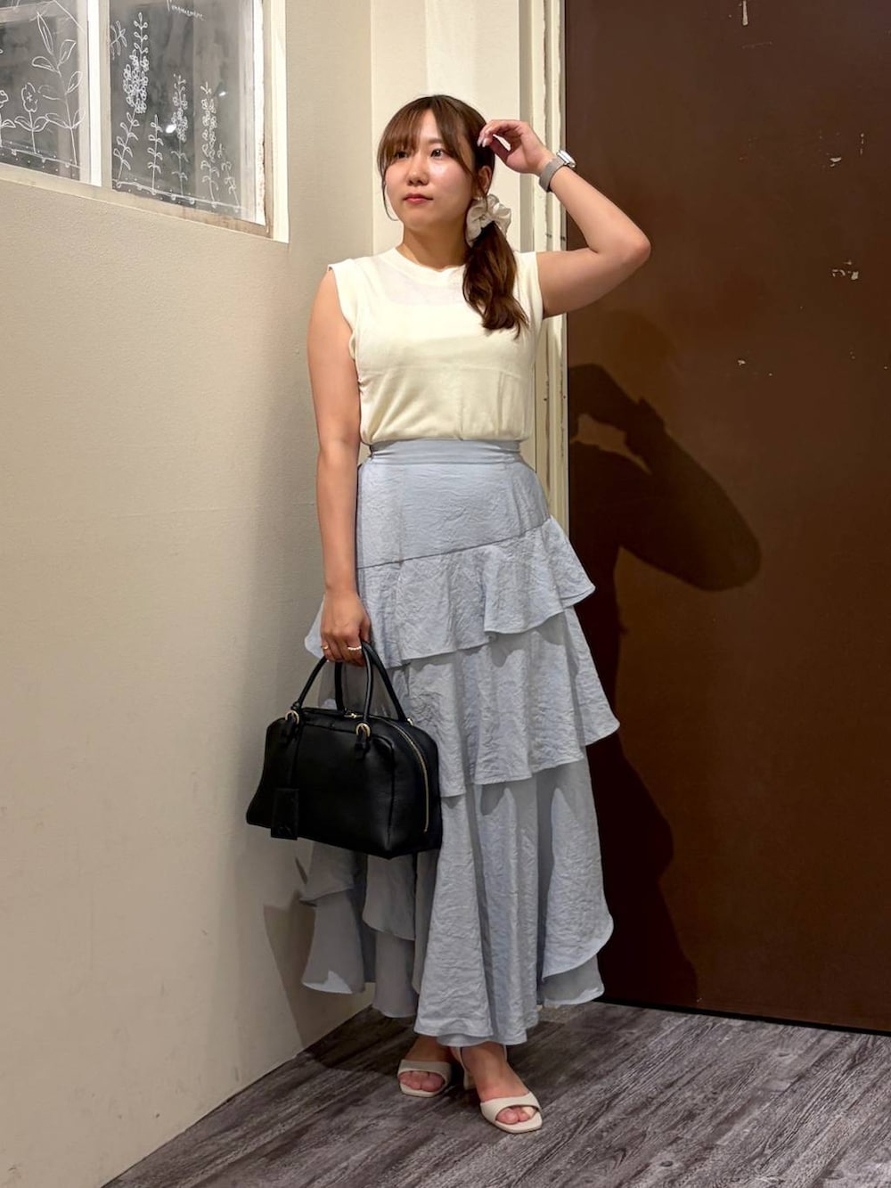 ホワイト系のニット/セーター、グレー系のスカート、ブラック系のハンドバッグを着用したレディースの夏コーディネートの4枚目の写真
