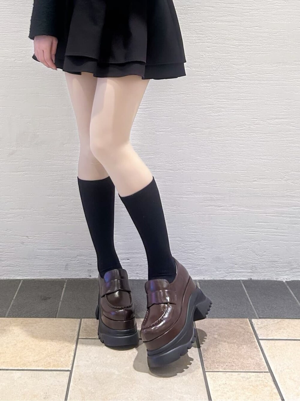 ブラウン系のパンプスを着用したレディースの冬コーディネートの2枚目の写真