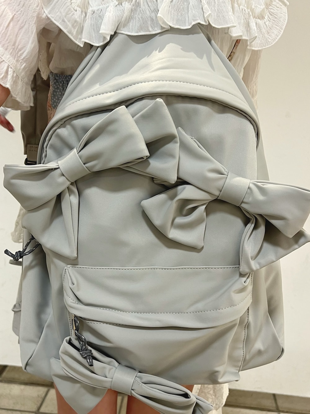 ピンク系のシャツ/ブラウス、ホワイト系のシャツ/ブラウス、グレー系のバックパック/リュックを着用したレディースの夏コーディネートの9枚目の写真
