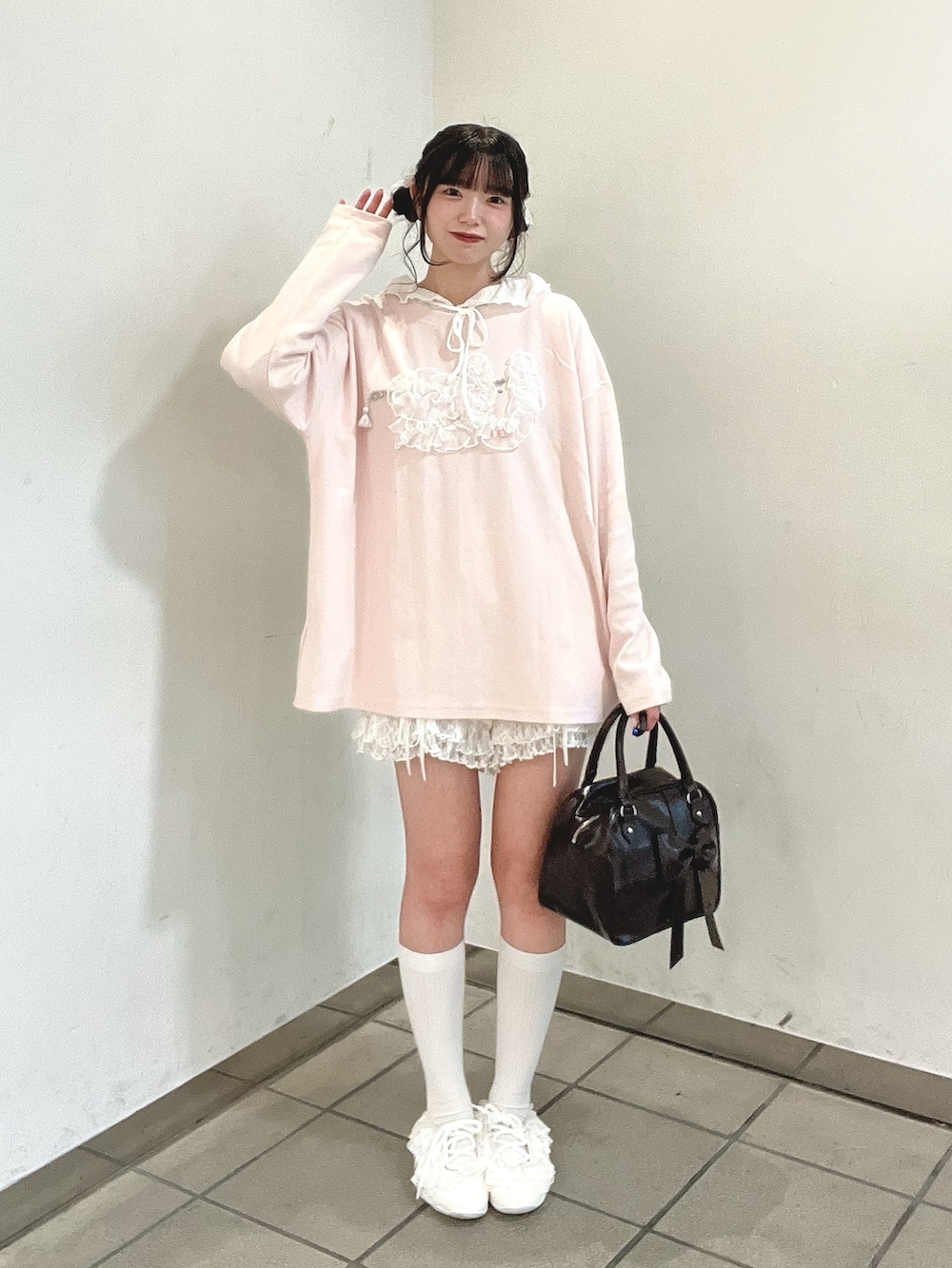ブラウン系のハンドバッグ、ホワイト系のその他パンツ、ホワイト系のスニーカーを着用したレディースの秋コーディネートの4枚目の写真