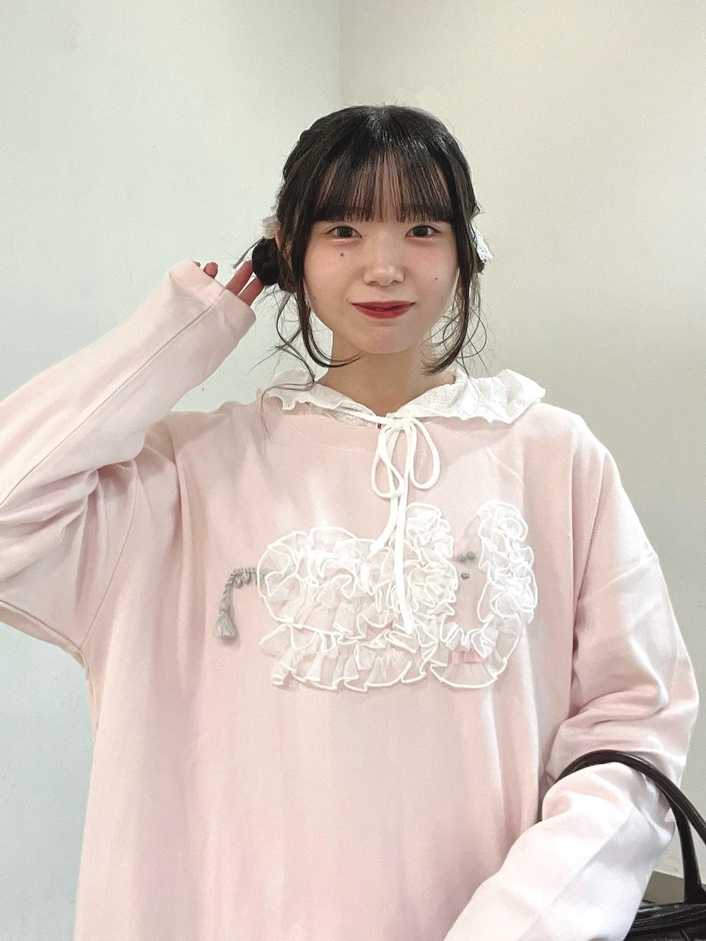 ブラウン系のハンドバッグ、ホワイト系のその他パンツ、ホワイト系のスニーカーを着用したレディースの秋コーディネートの5枚目の写真