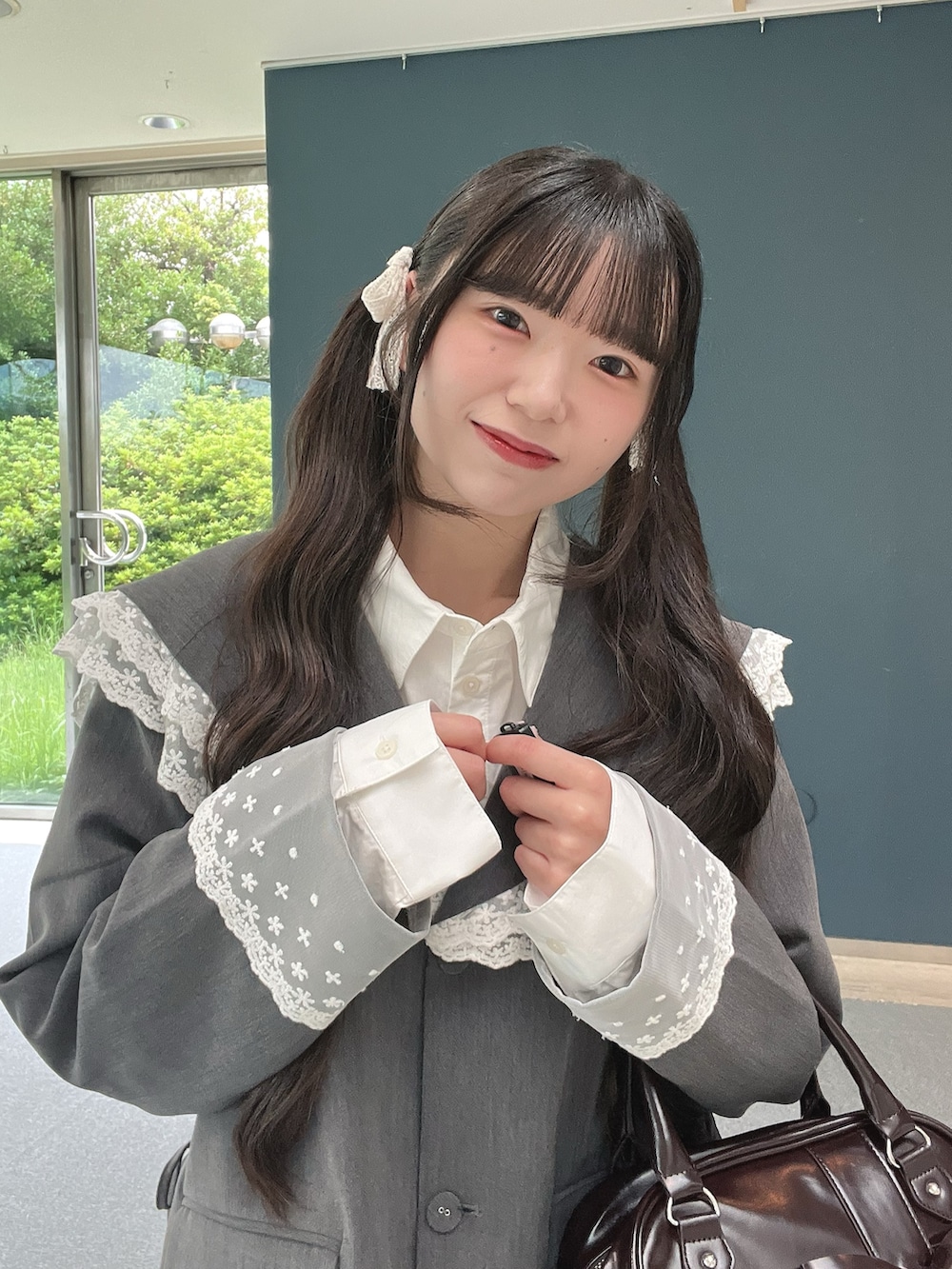 ブラウン系のハンドバッグ、ホワイト系のその他パンツ、ブラック系のパンプスを着用したレディースの秋コーディネートの5枚目の写真