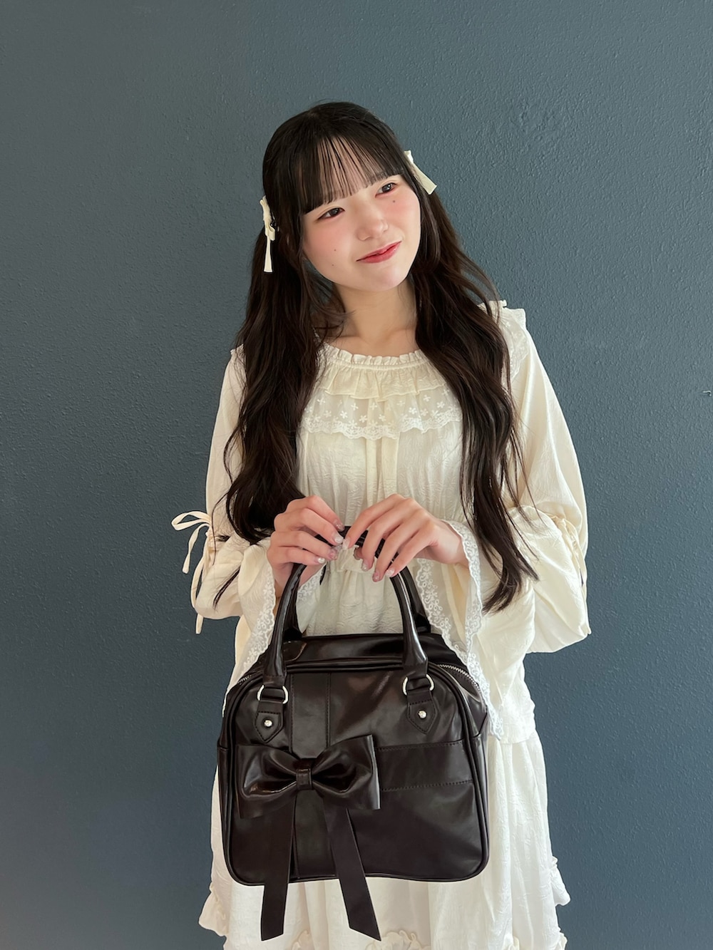 ピンク系のスニーカー、ホワイト系のワンピース、ブラウン系のハンドバッグを着用したレディースの夏コーディネートの6枚目の写真