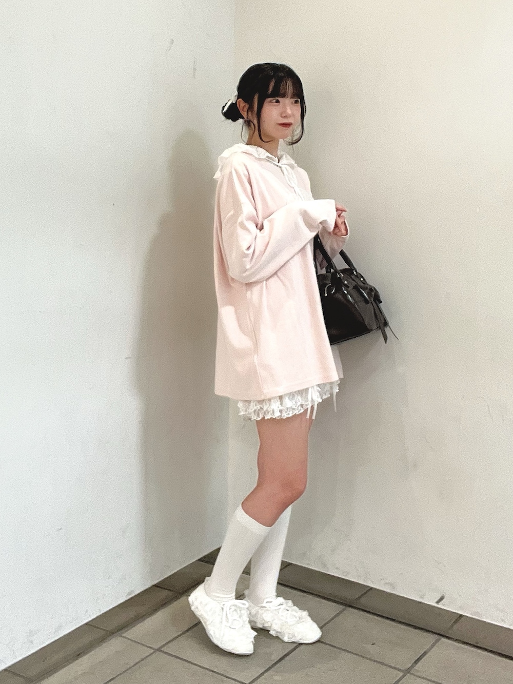 ブラウン系のハンドバッグ、ホワイト系のその他パンツ、ホワイト系のスニーカーを着用したレディースの秋コーディネートの3枚目の写真