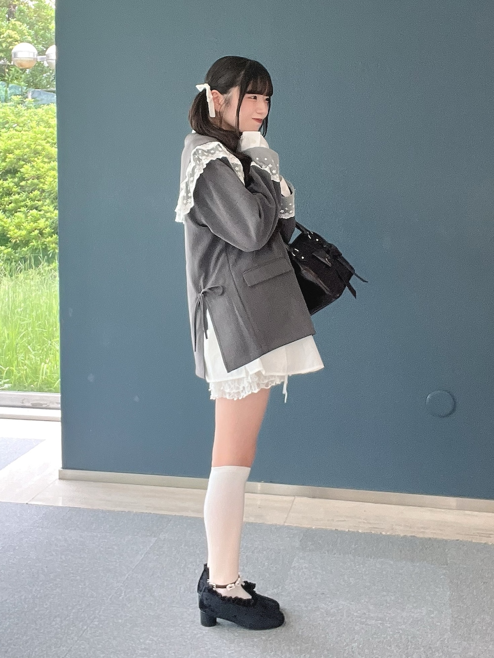 ブラウン系のハンドバッグ、ホワイト系のその他パンツ、ブラック系のパンプスを着用したレディースの秋コーディネートの2枚目の写真
